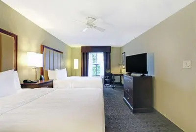 a hotel room with two beds and a flat screen tv at Homewood Suites by Hilton Cambridge-Waterloo, Ontario in Cambridge