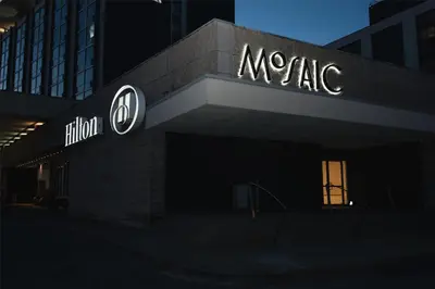 a building with a sign on the side of it at Hilton Toronto Airport Hotel & Suites in Mississauga