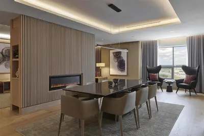 a dining room with a table and chairs and a fireplace at Hilton Toronto Airport Hotel & Suites in Mississauga