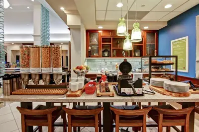 a restaurant with a table with chairs and plates at Hilton Garden Inn Toronto/Burlington in Burlington