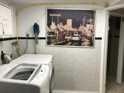 a washing machine in a room with a picture on the wall at Pring Guesthouse in Hamilton