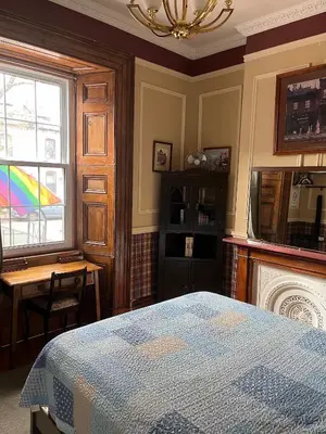 a bedroom with a bed and a window with a rainbow at Pring Guesthouse in Hamilton