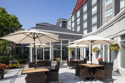 a patio with tables and umbrellas in front of a building at Hilton Garden Inn Toronto/Ajax in Ajax