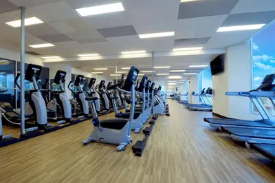 a gym with a lot of treadmills and ellipticals at Hilton Suites Toronto-Markham Conference Centre & Spa in Markham