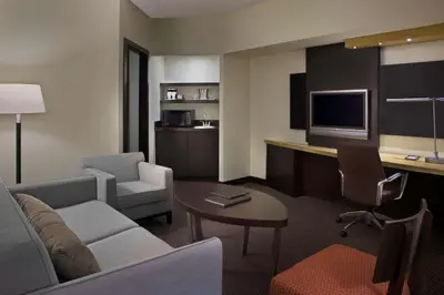a hotel room with a couch and a desk with a tv at Hilton Suites Toronto-Markham Conference Centre & Spa in Markham