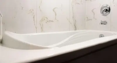 a white bath tub in a bathroom with marble walls at Hilton Suites Toronto-Markham Conference Centre & Spa in Markham