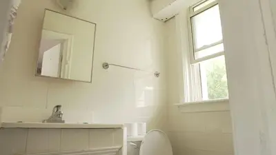 a bathroom with a toilet and a sink and a mirror at Pleasant Stay Motel in Ancaster