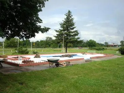 a swimming pool with a picnic table in a park at Pleasant Stay Motel in Ancaster