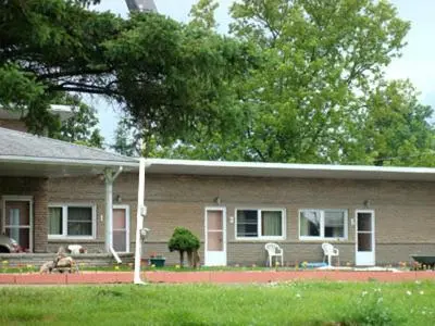 a house with a dog sitting in front of it at Pleasant Stay Motel in Ancaster