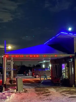a gas station with a blue light at night at Pleasant Stay Motel in Ancaster