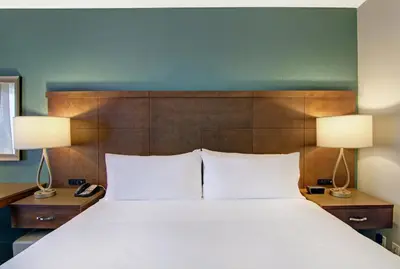 a bedroom with a large white bed with two lamps at Staybridge Suites Toronto - Vaughan South by IHG in Vaughan