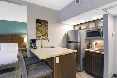 a small kitchen in a hotel room with a bed at Staybridge Suites Toronto - Vaughan South by IHG in Vaughan