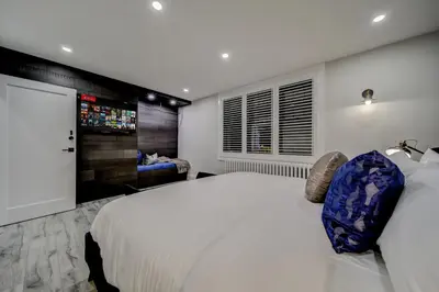 a bedroom with a large white bed and a television at The Westlake in Toronto
