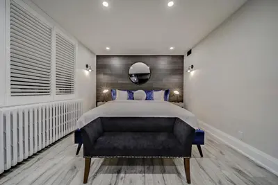 a bedroom with a large bed and a black couch at The Westlake in Toronto