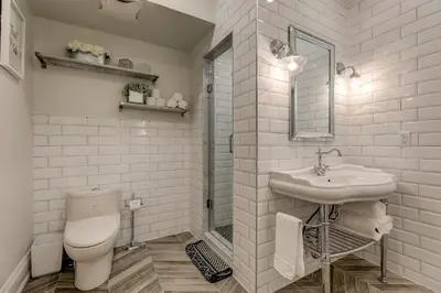 a white bathroom with a toilet and a sink at The Westlake in Toronto