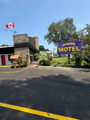 a motel sign on the side of a parking lot at Crestwood Motel in Burlington