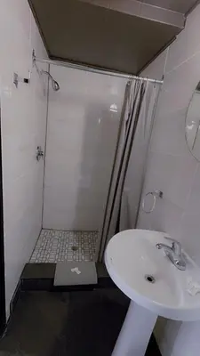 a bathroom with a shower and a white sink at Crestwood Motel in Burlington