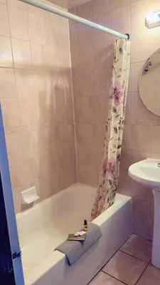 a bathroom with a bath tub and a sink at Crestwood Motel in Burlington