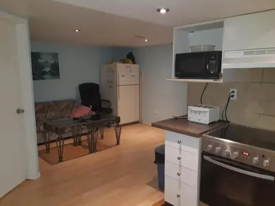 a kitchen and living room with a couch and a table at McMaster Accommodations in Hamilton