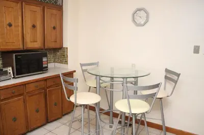a kitchen with a table and chairs and a microwave at McMaster Accommodations in Hamilton