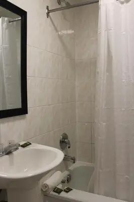 a bathroom with a sink and a white shower curtain at Super 7 Motel London in London