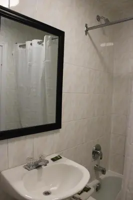 a bathroom with a sink and a shower with a mirror at Super 7 Motel London in London
