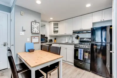 a kitchen with white cabinets and a wooden table at Blue Mountain Getaway at North Creek Resort King Bed in Blue Mountains