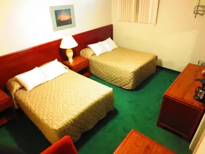 a hotel room with two beds and a table at Canadiana Motel in Hanover