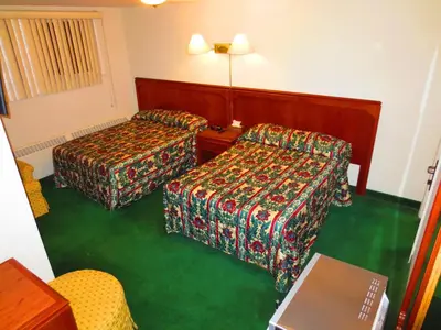 a hotel room with two beds and a table at Canadiana Motel in Hanover