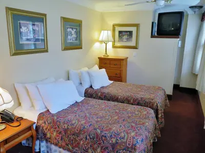 a hotel room with two beds and a tv at Madison Manor Boutique Hotel in Toronto