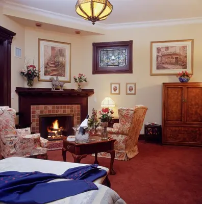 a living room with a fireplace and a table and chairs at Madison Manor Boutique Hotel in Toronto