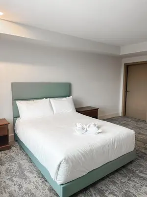 a bedroom with a white bed with two white roses on it at Living Stone Golf Resort in Collingwood