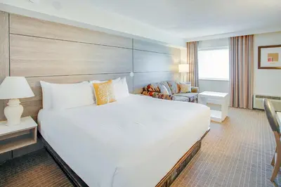 a hotel room with a large bed and a chair at Living Stone Golf Resort in Collingwood