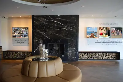 a lobby with a fireplace and a table in front of it at Living Stone Golf Resort in Collingwood