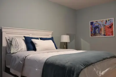 a bedroom with a bed with blue and white pillows at Hammer Haus in Waterloo
