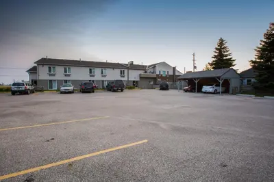 a parking lot with cars parked in front of a building at The Village Inn in Elora