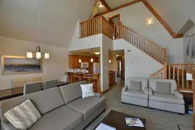 a living room with a couch and a kitchen at The Blue Escape Blue Mountain Chalet in Blue Mountains