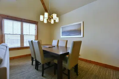 a dining room with a wooden table and chairs at The Blue Escape Blue Mountain Chalet in Blue Mountains