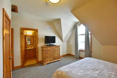 a bedroom with a bed and a television on a dresser at The Blue Escape Blue Mountain Chalet in Blue Mountains
