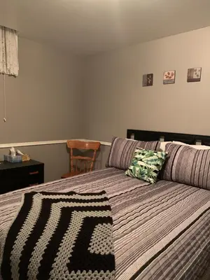 a bedroom with a bed with a couch and a chair at Evening Shade in Fergus