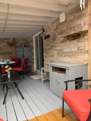 a patio with a table and chairs and a brick wall at Evening Shade in Fergus