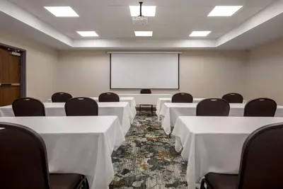 a conference room with tables and chairs and a whiteboard at Hampton Inn by Hilton Brampton - Toronto in Brampton