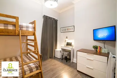 a dorm room with a bunk bed and a desk at The Clarence Park in Toronto