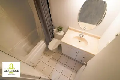 a bathroom with a sink and a mirror and a toilet at The Clarence Park in Toronto