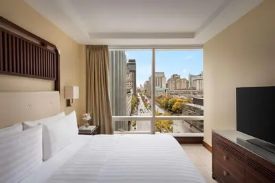 a hotel room with a large bed and a large window at Shangri-La Toronto in Toronto