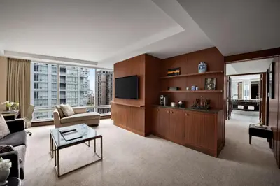 a living room with a couch and a tv at Shangri-La Toronto in Toronto