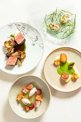 four plates of food on a white table at Shangri-La Toronto in Toronto