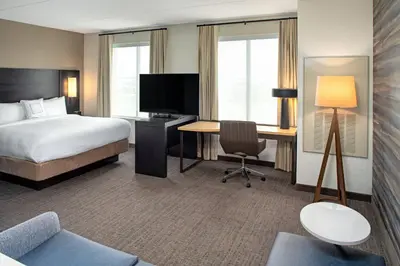 a hotel room with a bed and a desk with a computer at Residence Inn by Marriott Toronto Mississauga West in Mississauga