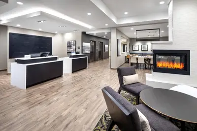 a lobby with a fireplace and a table and chairs at Residence Inn by Marriott Toronto Mississauga West in Mississauga