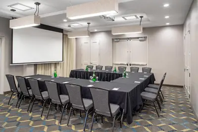 a conference room with a table and chairs and a screen at Residence Inn by Marriott Toronto Mississauga West in Mississauga